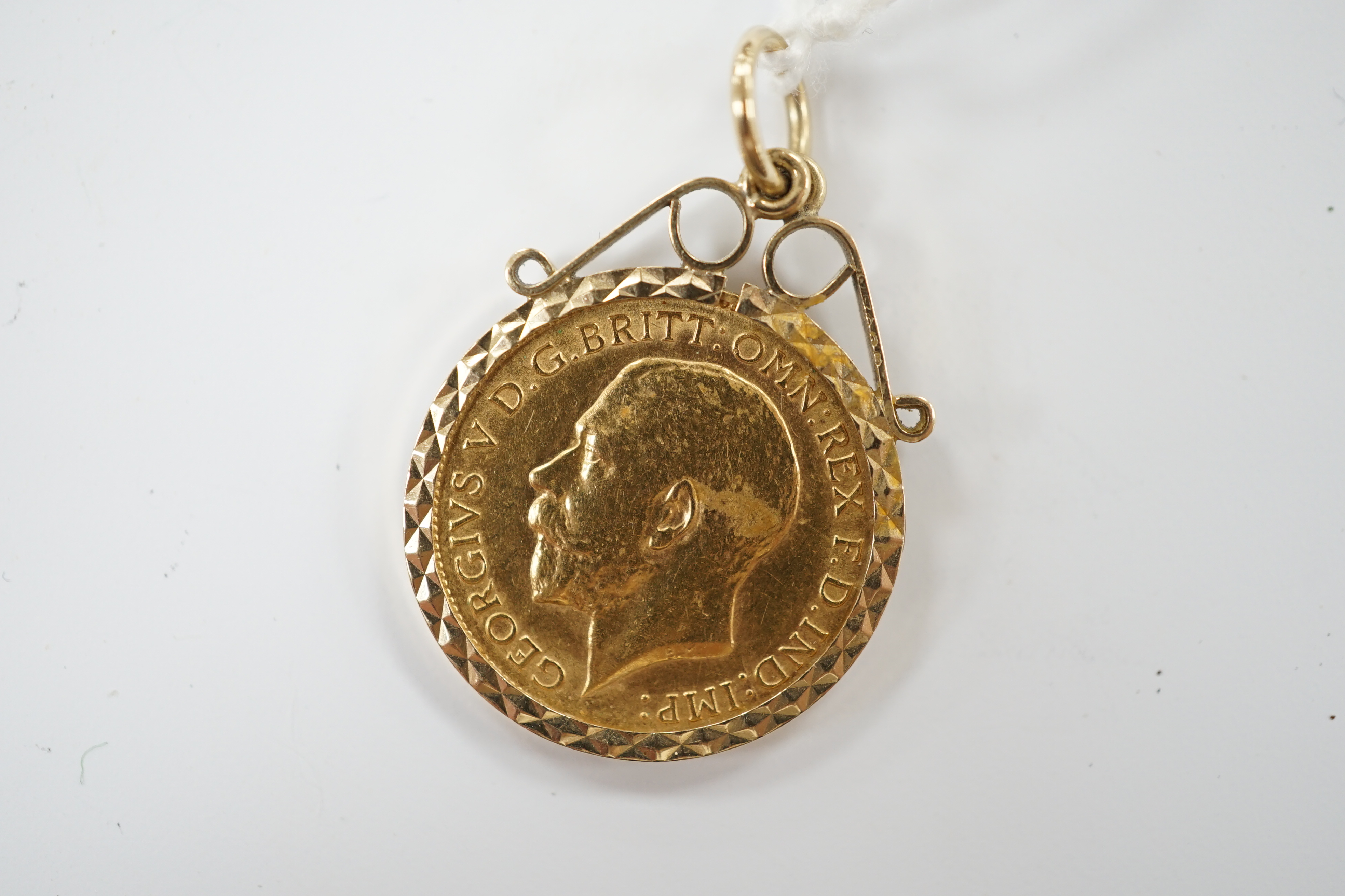 A George V 1911 gold half sovereign, in a later 9ct gold pendant mount